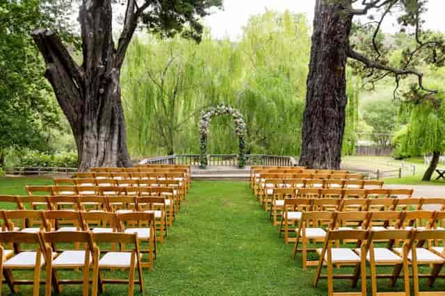Outdoor wedding ceremony at Radonich Ranch with floral arch and wooden chairs.