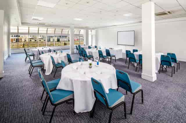 Pilgrim Suite meeting room with round tables, ideal for workshops and conferences.