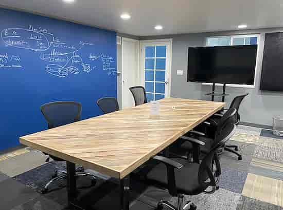 Modern meeting room with wooden table, ergonomic chairs for collaborative events.