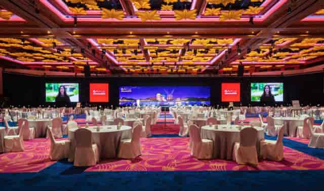 Elegant event space with round tables and floral ceiling at Resorts World Convention Centre.