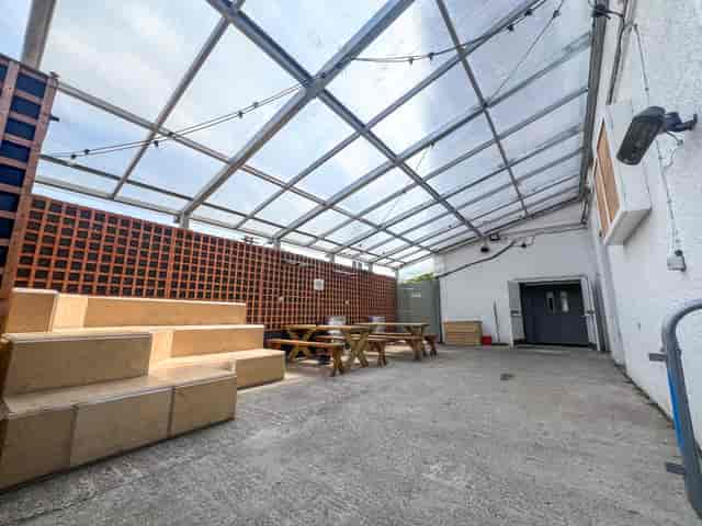 Versatile outdoor event space with clear roof, tiered seating, ideal for gatherings.