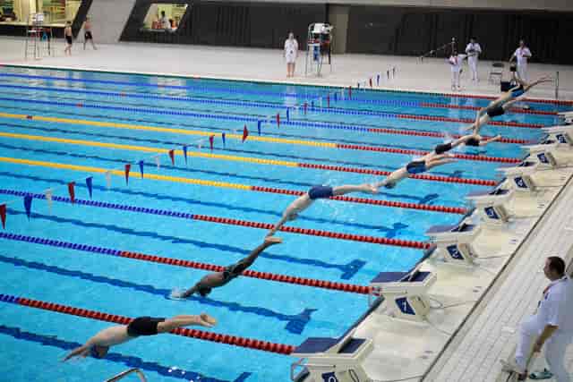 Dynamic swimming competition at London Aquatics Centre, showcasing athlete dives and engagement.