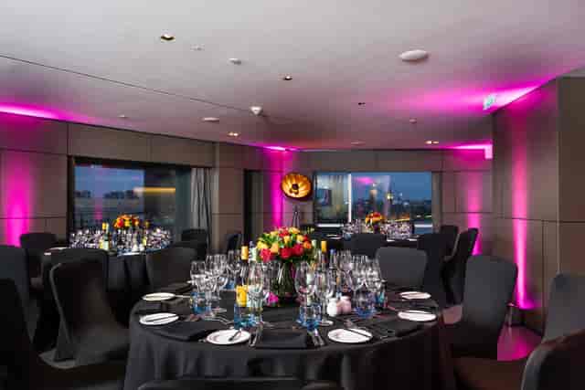 Riverview Lounge dinner setup with floral centerpieces and pink lighting, ideal for events.
