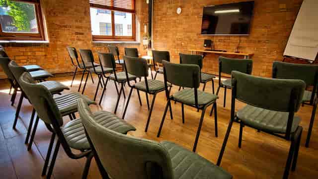 Purple Room in Remark! Events with green chairs, ideal for workshops and meetings.