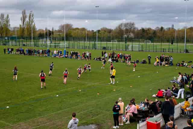 Outdoor rugby match at King's House School with enthusiastic spectators and vibrant atmosphere.