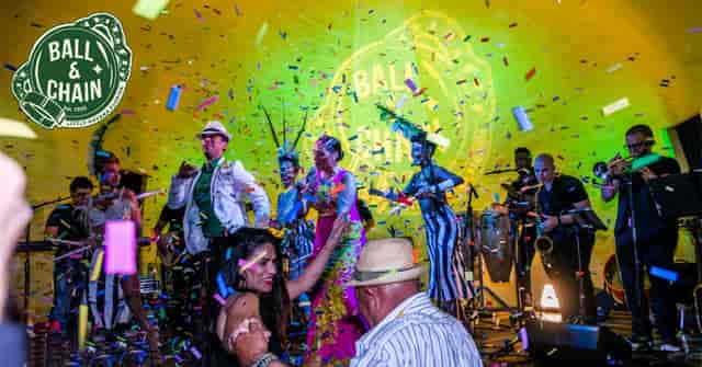 Vibrant bar event at Ball & Chain with lively performers and colorful confetti.
