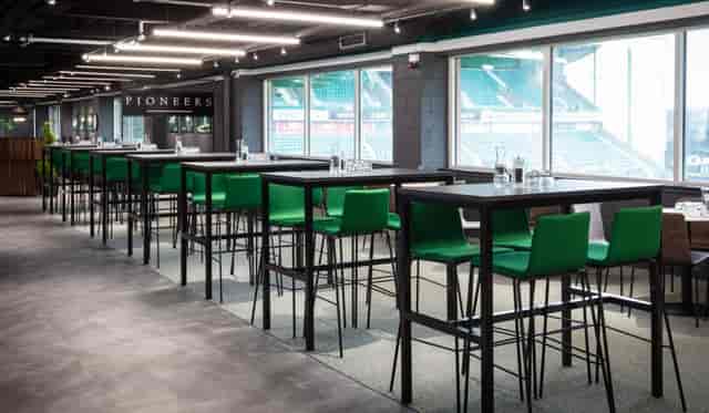 Modern Edinburgh Club event space with high tables and green chairs for networking gatherings.
