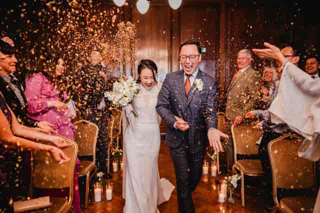 Joyful wedding celebration in The Drawing Room, Manchester Hall with confetti shower.