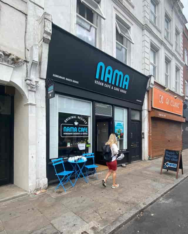 Vegan café storefront with outdoor seating, ideal for casual networking events.