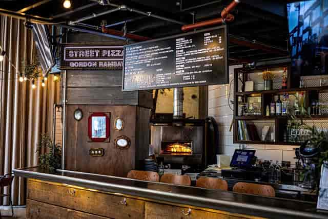 Vibrant Street Pizza venue with rustic bar, ideal for casual networking events.