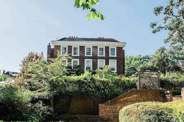 Charming Burgh House library venue for weddings and corporate retreats, surrounded by greenery.