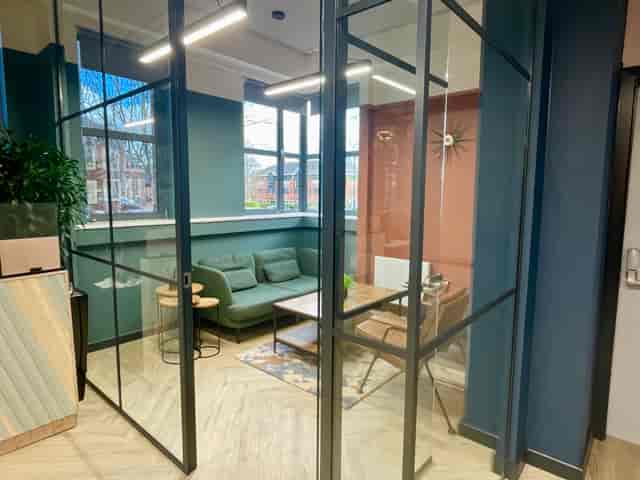Modern meeting space with glass walls in Wizu Workspace, ideal for collaboration and brainstorming.