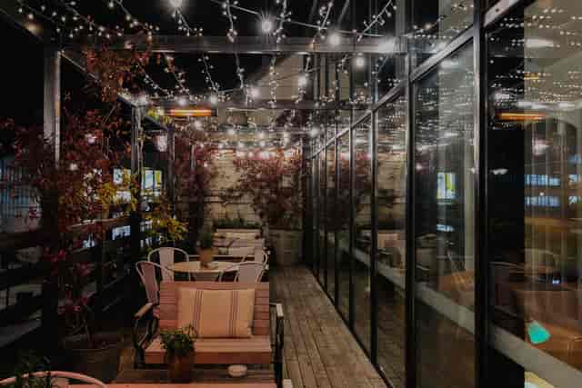 Outdoor event space at Table 601 with string lights and glass walls for gatherings.