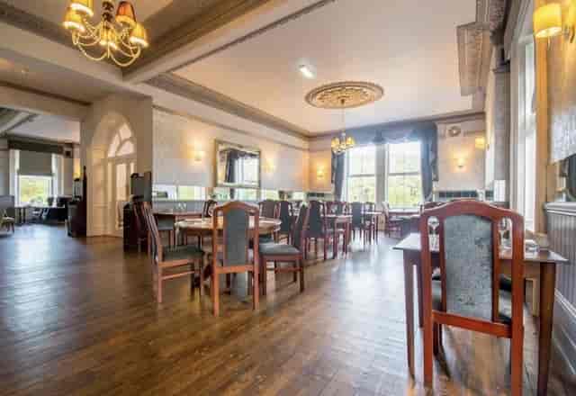 Elegant event space in Armstrong Manor with wooden flooring for corporate and social gatherings.