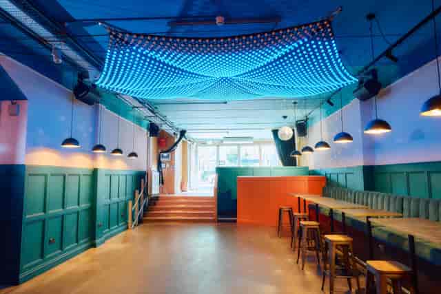 Main Bar & Terrace at Colours Hoxton, modern event space with blue lighting for gatherings.