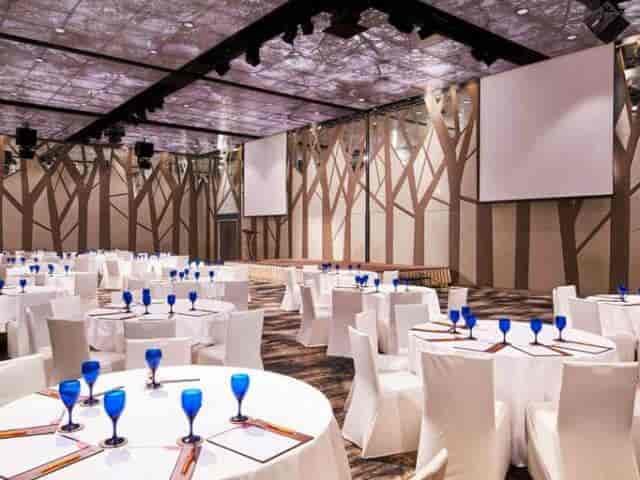 Elegant event space with round tables, blue glassware for conferences and banquets.