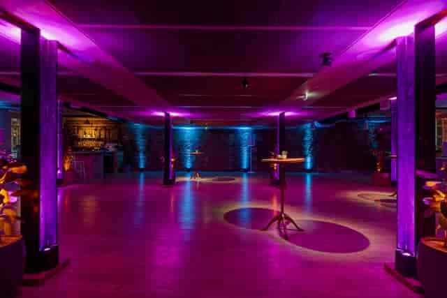 Stylish event space at The Forum with vibrant purple lighting for corporate gatherings.