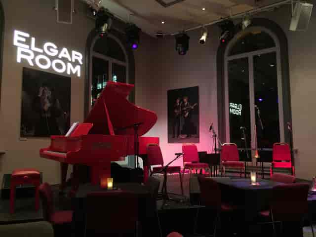 Elgar Room Brasserie with red piano, ideal for music events and private gatherings.