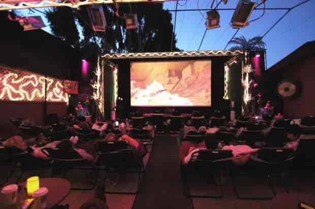Outdoor cinema Cabana love booth with cozy lounge chairs for unique events.