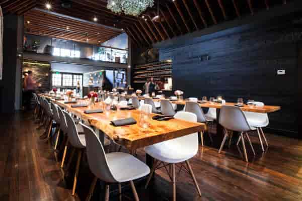 Stylish Mezzanine dining space with wooden table for corporate events and gatherings.