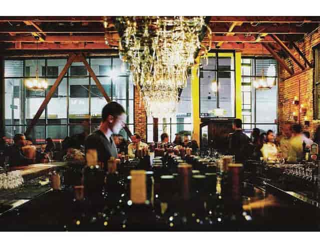 Vibrant restaurant bar with elegant chandeliers, ideal for networking events.