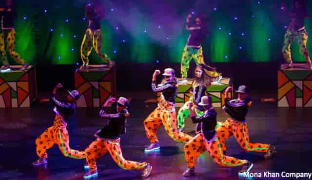 Intensive Training Class dancers in colorful outfits performing dynamic choreography on stage.