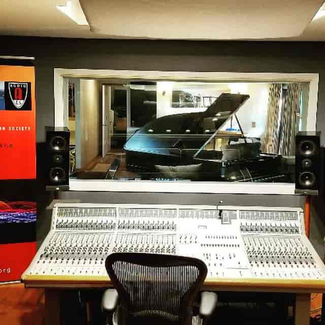 Professional recording studio with grand piano for music production and creative workshops.