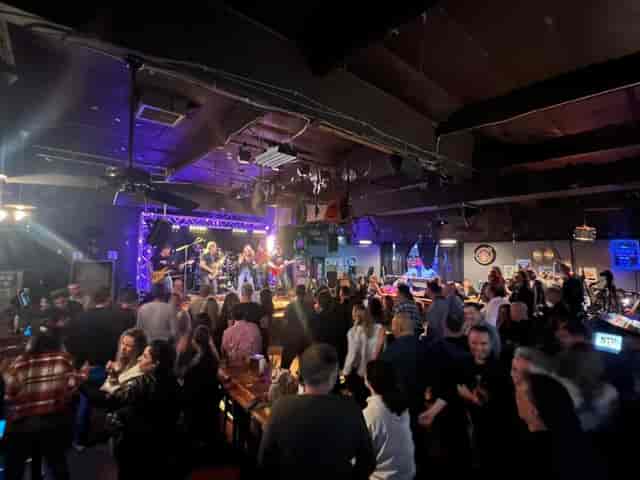 Vibrant live music event at Quarter Note Bar & Grill with packed audience and lively atmosphere.
