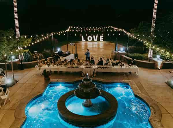Outdoor wedding venue at Wolfe Heights Winery with string lights and illuminated "LOVE" sign.