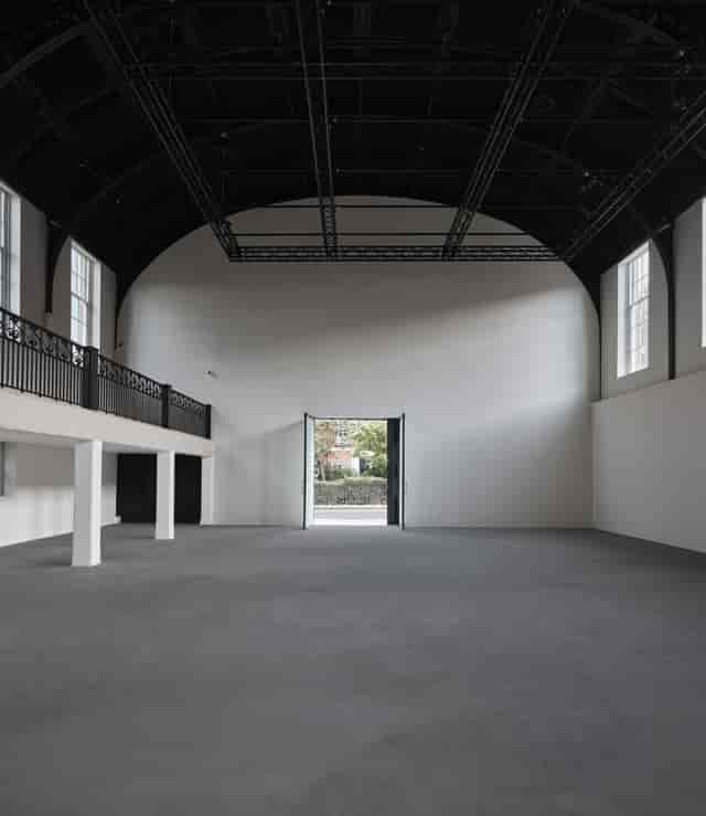Spacious minimalist event venue with high ceilings for modern conferences and receptions.