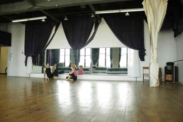 Spacious studio with polished floors for dance workshops and fitness classes.