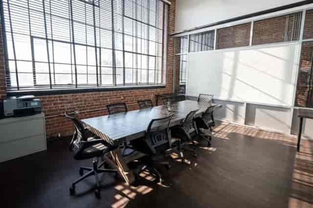 Modern meeting room in HQ Newark with wooden table, ideal for collaborative events.