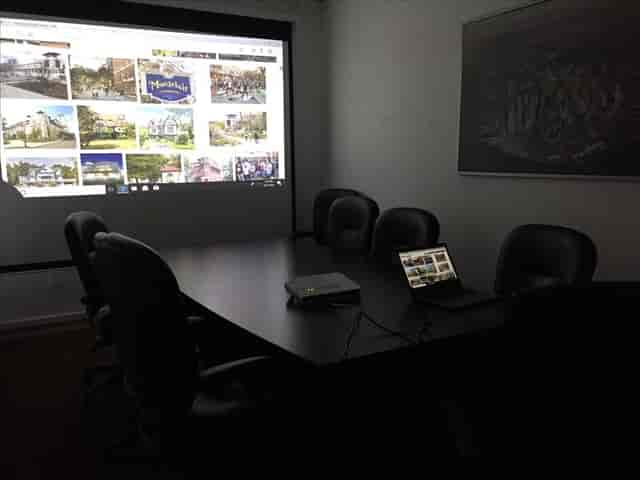 Modern meeting room with projection screen for presentations in Montclair Workspace.