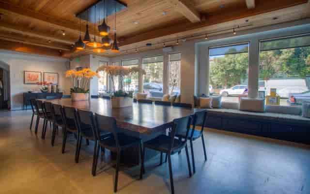 Stylish meeting space with wooden table and black chairs, ideal for gatherings and brainstorming.