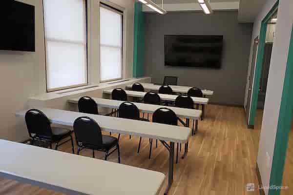 Training room in NYC conference center with bright natural light and classroom-style layout.