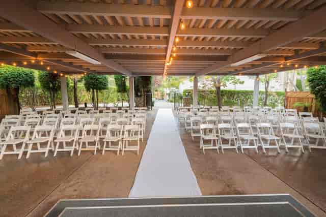 Outdoor wedding venue at Los Gatos Lodge with white chairs and string lights.