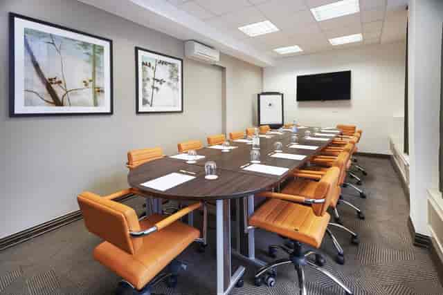 Meeting room with oval table and ergonomic chairs at DoubleTree London for professional events.