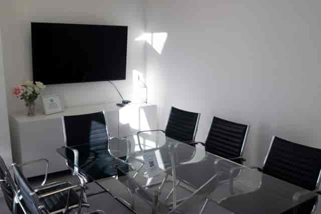 Modern Executive Boardroom with glass table, ideal for meetings and presentations.