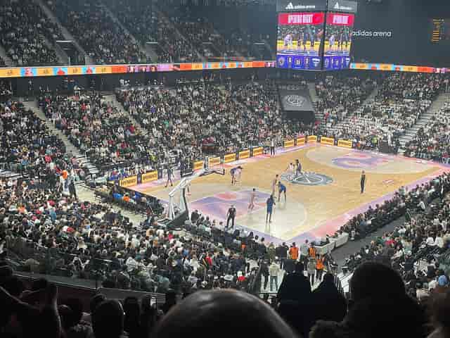 Packed basketball court at Accor Arena during a live game, showcasing vibrant fan energy.