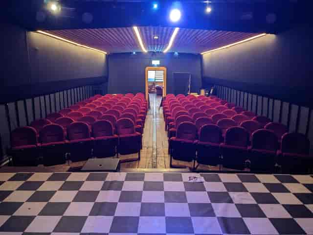 Theatre auditorium with red seating, perfect for presentations and performances.