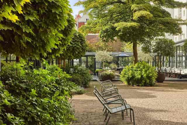 Serene outdoor event venue at Pulitzer Amsterdam with lush greenery and versatile seating.