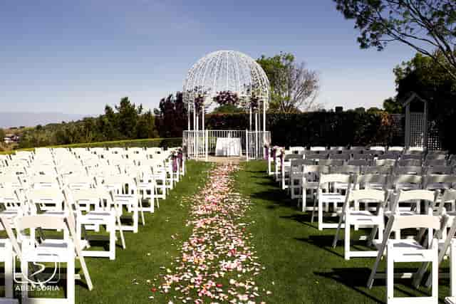 Outdoor wedding ceremony at Saratoga Country Club with floral aisle and gazebo.