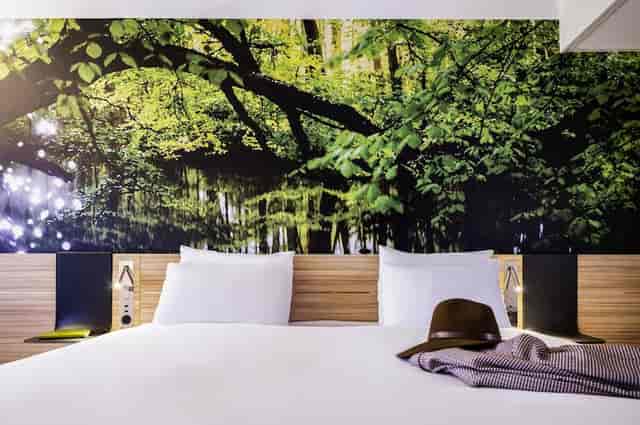 Serene hotel room with nature mural, ideal for retreats and wellness events.