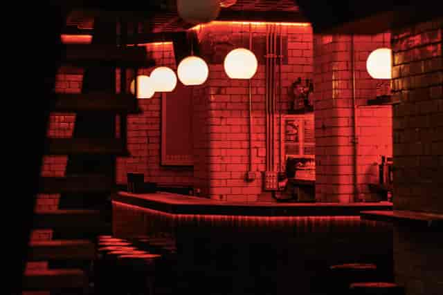 Stylish bar with red ambiance, perfect for networking events and cocktail receptions.