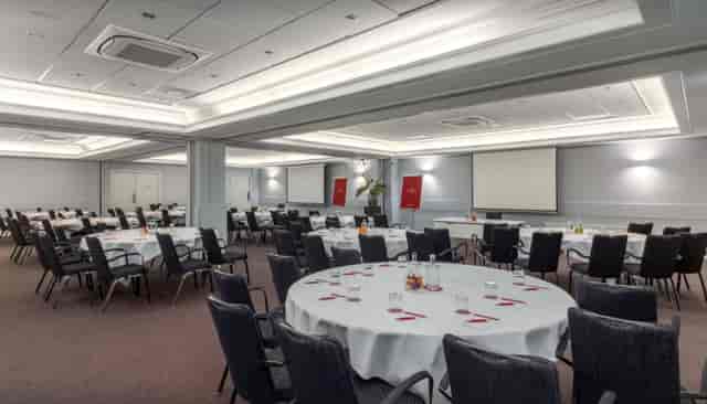 Elegant event space with round tables for corporate meetings and banquets.