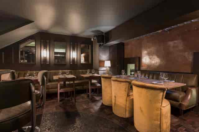 Sophisticated Ember Bar dining space with plush seating for intimate events and networking.