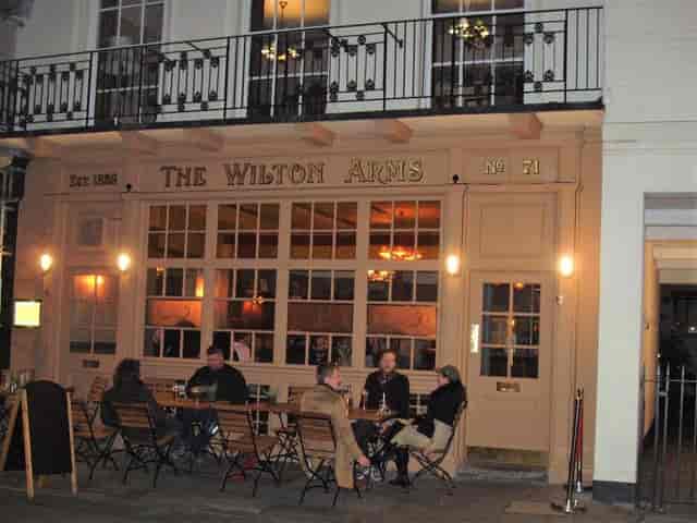 Cozy Victorian pub exterior with outdoor seating for casual networking events.
