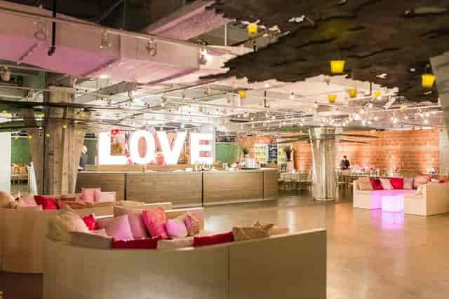 Stylish event space with "LOVE" sign, perfect for weddings and corporate functions.