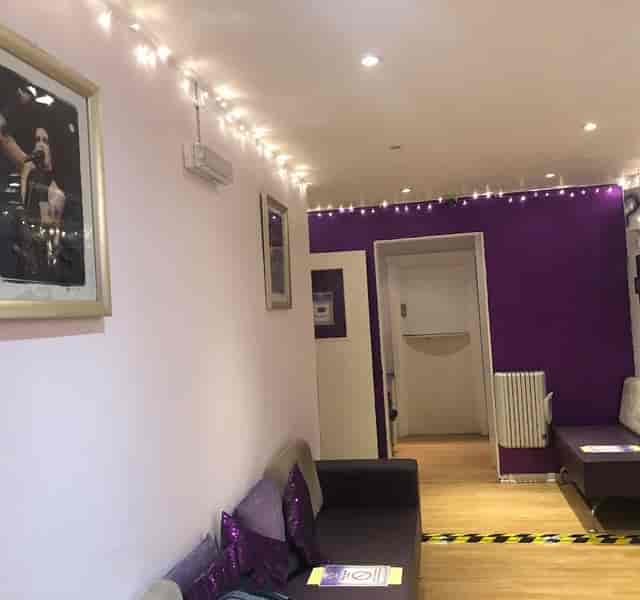 Cozy recording studio with purple accent wall, perfect for intimate events and workshops.