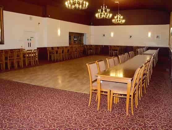 Spacious function room in Langley Hall with elegant chandeliers for events and meetings.